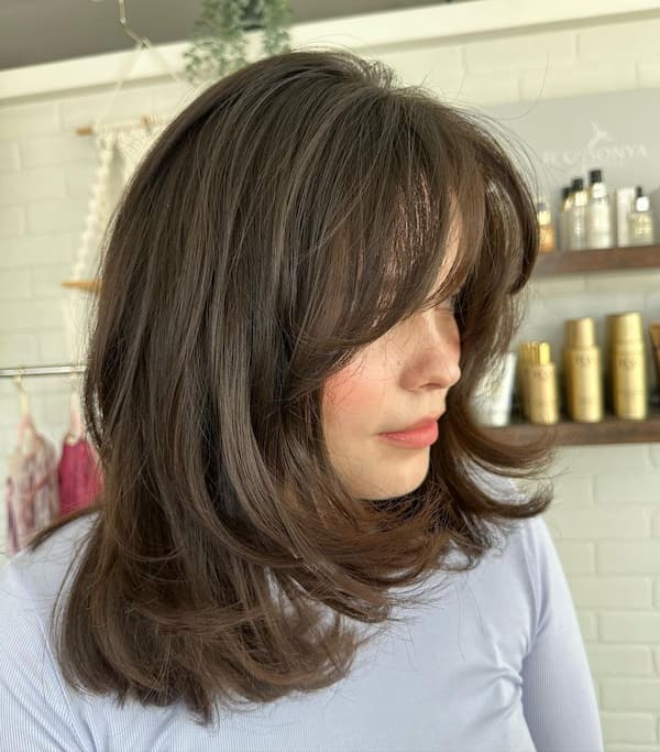 Bouncy Layered Haircut with Curvy Ends and Bangs