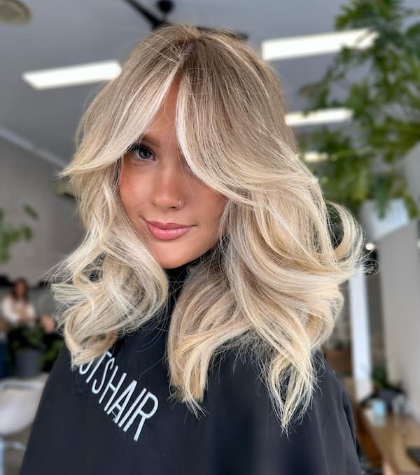 Voluminous Blonde Haircut with Bangs