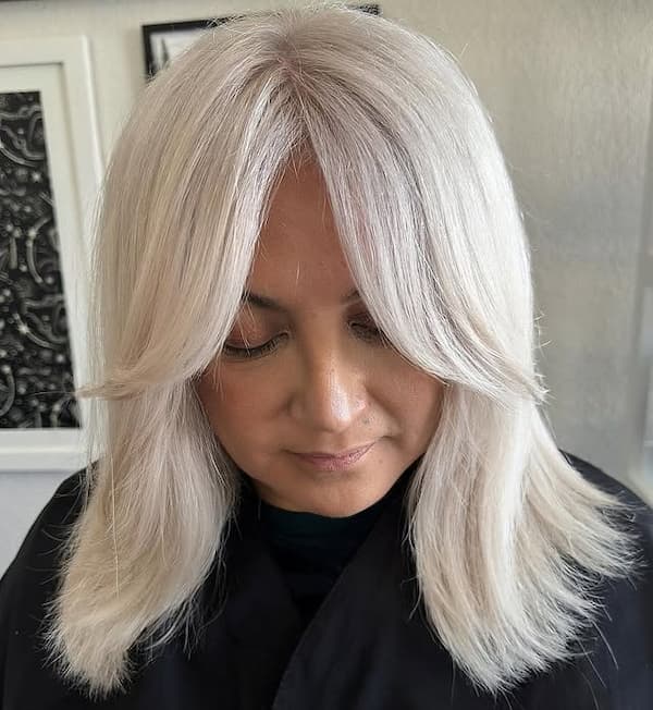 Platinum Blonde Mid-Length Haircut with Curtain Bangs 
